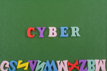 CYBER word on green background composed from colorful abc alphabet block wooden letters, copy space...