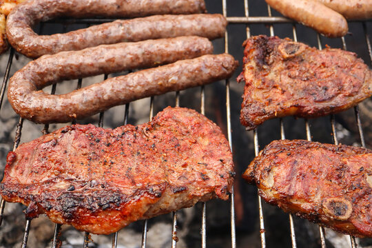 grilled meat on the grill. South African braai including Boerewors wors sausage and steak, chops