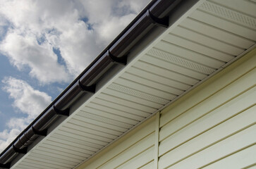 Brown plastic rain gutter system on a house