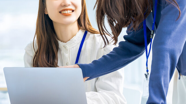 ノートパソコンを使ってミーティングをする2人の若い日本人ビジネスウーマン