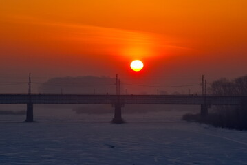 Novokuznetsk, Russia. The South of Western Siberia. The rising sun over the railway bridge on a...