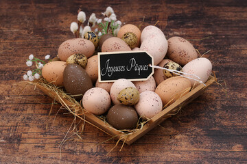 Carte de voeux Joyeuses Pâques. Nid décoratif avec des œufs de Pâques et le message Joyeuses...