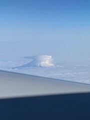 飛行機から見た雲のかかった富士山