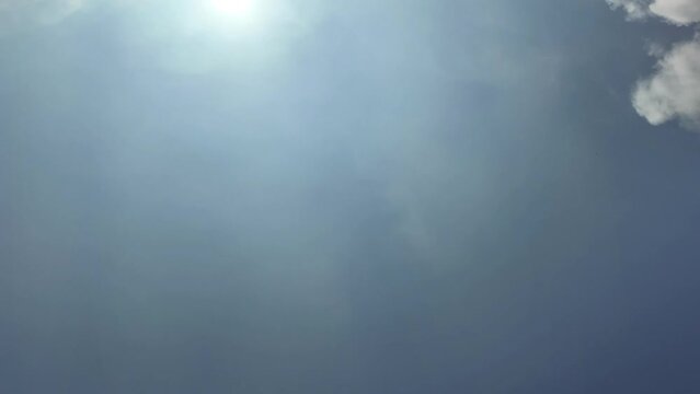 time lapse of fast moving clouds at the edge of a sunny blue sky background with copy space, space for product presentation or text