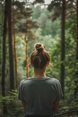 Fotobehang A person attending a mental health retreat to focus on self-care and renewal. Caucasian Woman in forest admiring trees amidst natural landscape © ivlianna