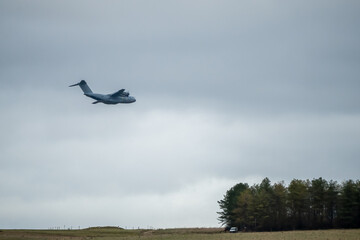 RAF Royal Air Force Airbus A400M Atlas military cargo plane, flying close to treetops on a cargo...
