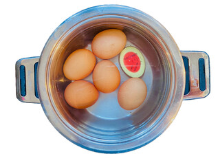 Jajka ugotowane na twardo w wodzie w garnku metalowym. Timer do mierzenia czasu gotowania wskazujący twardość. Widok z góry. Przezroczyste tło.