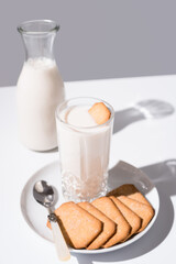 Vaso de leche y botella llena de leche. Desayuno con galletas de canela