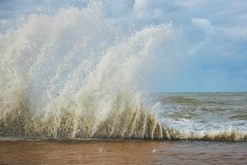 A storm and splashes of waves on the shore of the sea or ocean. The impact of water on the shore
