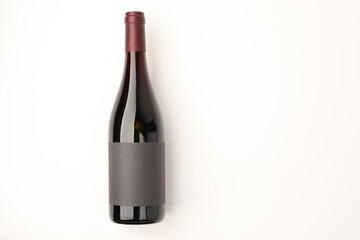 Bottle of tasty red wine on white background, top view. Space for text