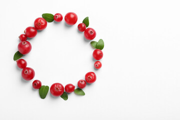 Frame made of fresh cranberries and green leaves on white background, flat lay. Space for text