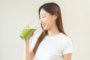 Green detox juice concept, Beautiful asian young woman hand holding vegetable smoothie bottle for...