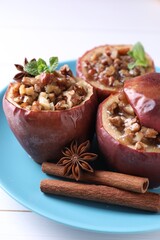 Tasty baked apples with nuts, honey, spices and mint on white wooden table, closeup