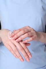 Woman applying cream on her hands, closeup