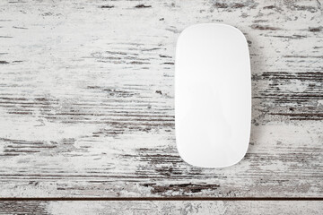 Wireless White Modern Computer Mouse on Light Wooden Background with Copy Space