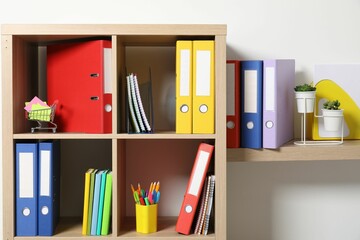 Obraz na płótnie Canvas Colorful binder office folders and other stationery on shelving unit indoors