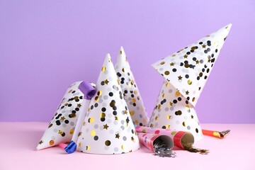 Party hats, confetti and blowers on color background