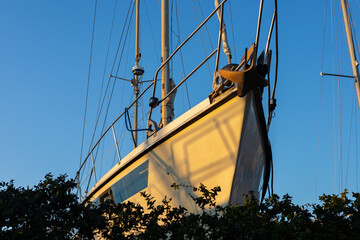 Sailboat moored at dock, casting shadows in sunset