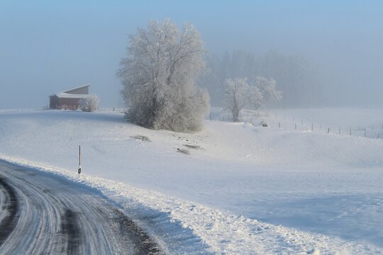 Kurvenreiche Landstraße in romantischer Winterlandschaft mit viel Schnee