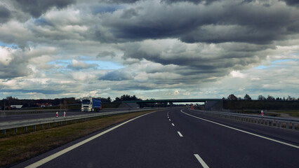 Fototapeta premium Truck on the German Autobahn and awesome clouds in the sky