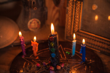 Table with candles and esoteric stuff. Herbs and wax around. Rite concept 
