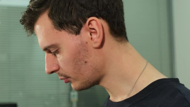 Professional taster assesses coffee samples by tasting with spoon closeup. Before each new cup inspector dips spoon into boiling water