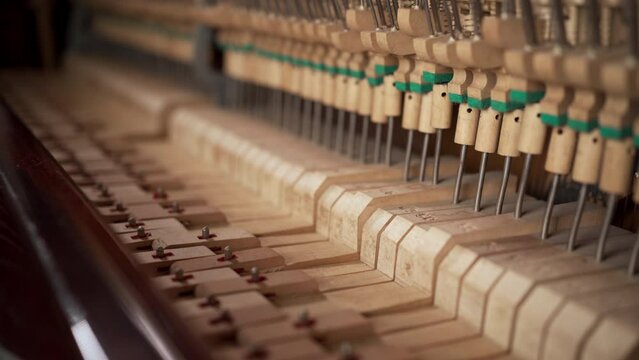 Close-up of musical mechanism of piano. Inside of old piano before tuning