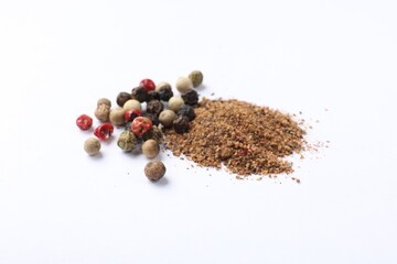 Aromatic spices. Pile of different ground and whole peppers on white background