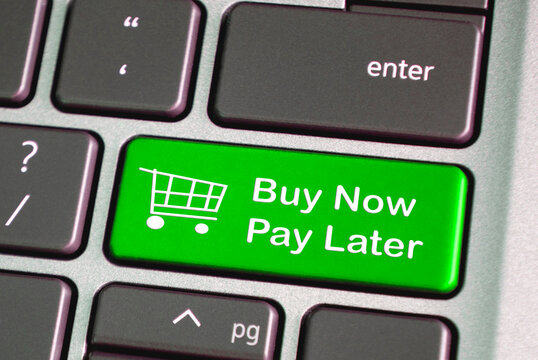 Buy now pay later text on green laptop keyboard. Business and online shopping concept