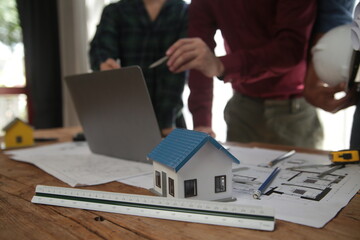 Engineers are consulting the team to design an architectural structure for clients with blueprints...