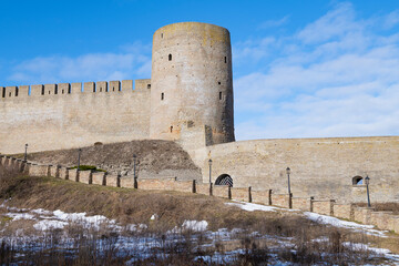 The ancient Long-neck tower of the Ivangorod fortress on a sunny March day. Leningrad region, Russia - 759851024