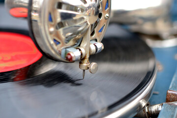 An old retro record playing on old vintage gramophone at flea market. Work of portable gramophone....