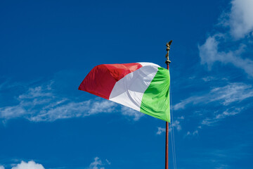 Włoska flaga na tle niebieskiego nieba. © Aneta