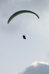 Stoke photo of a man flying in a glide. Concept of paragliding. Copy space.