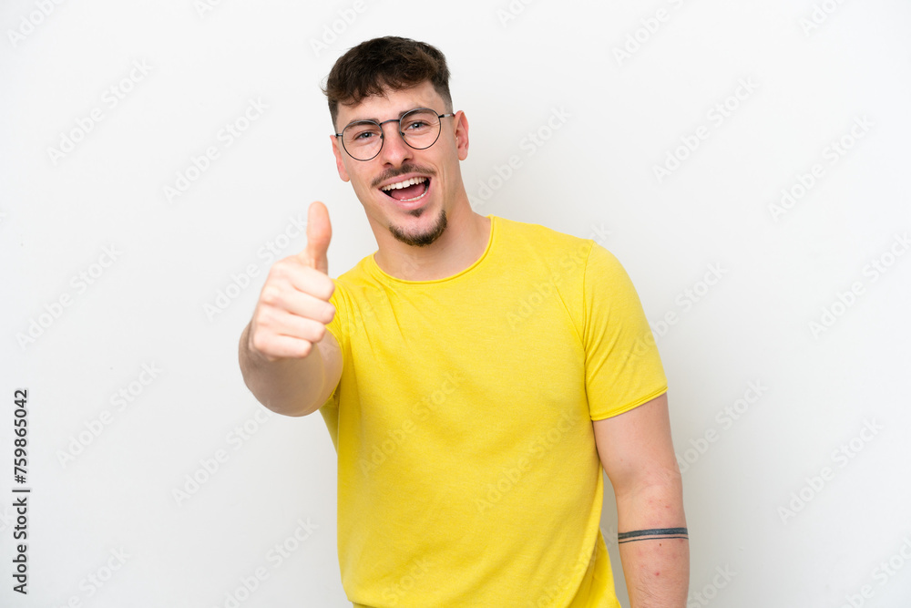 Wall mural Young caucasian handsome man isolated on white background with thumbs up because something good has happened