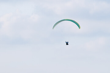 Stoke photo of a man flying in a glide. Concept of paragliding. Copy space.