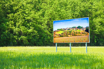 A advertising billboard shows the Tuscany landscape (Italy) -