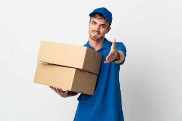 Young delivery blonde man isolated on white background shaking hands for closing a good deal