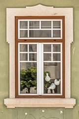Fototapeta na wymiar Colombes artificielles derrière une fenêtre ancienne dans la vieille ville de Peniche, Portugal