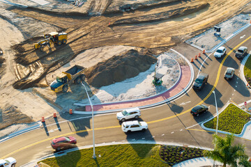 Roadworks construction site at roundabout intersection on American highway. Development of city...