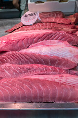 Pieces of freshly caught and chopped bluefin tuna for sale in the specialized fishmonger of a...