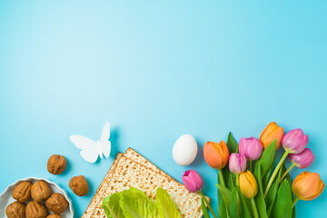Jewish holiday Passover concept with matzah and  spring tulip flowers on blue  background. Top view, flat lay composition - 759873441