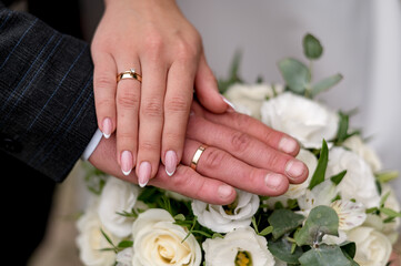 Obraz na płótnie Canvas Hands of newlyweds with wedding rings