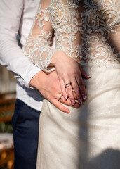 Hands of newlyweds with wedding rings	