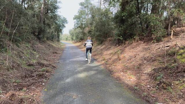  Piste cyclable bitum&eacute;e avec femme faisant du v&eacute;lo proche