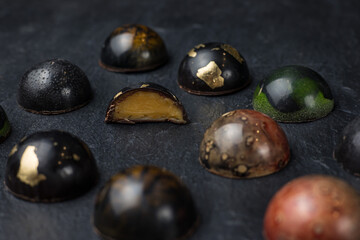 Box of assorted chocolates on dark background. Top view.
