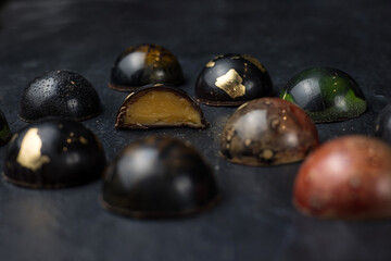Box of assorted chocolates on dark background. Top view.