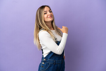 Young woman over isolated purple background proud and self-satisfied