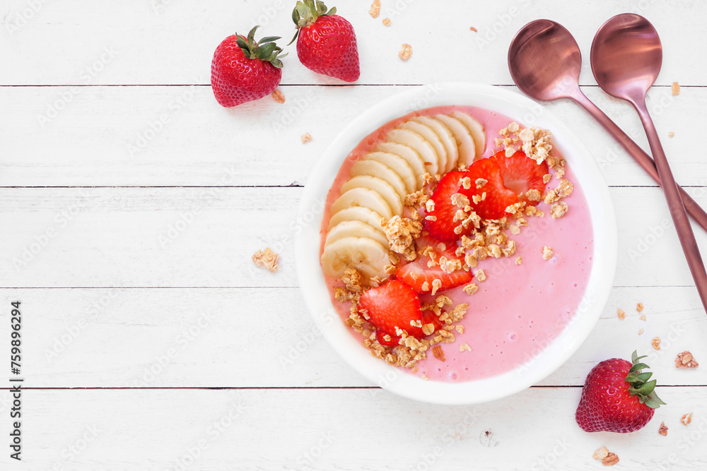 Sticker Healthy strawberry and banana smoothie bowl with granola. Overhead view table scene on a white wood background. Copy space.