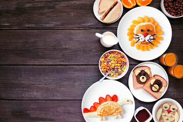 Fun child theme breakfast side border with an assortment of animal themed foods. Overhead view on a...